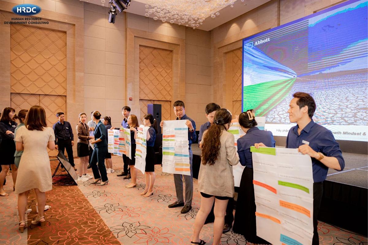 Lớp học đông học viên trong hội trường với các bảng nội dung